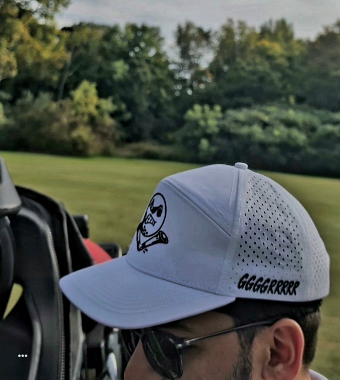 Customer wearing a white GGGGRRRRR GOLF cap on the course