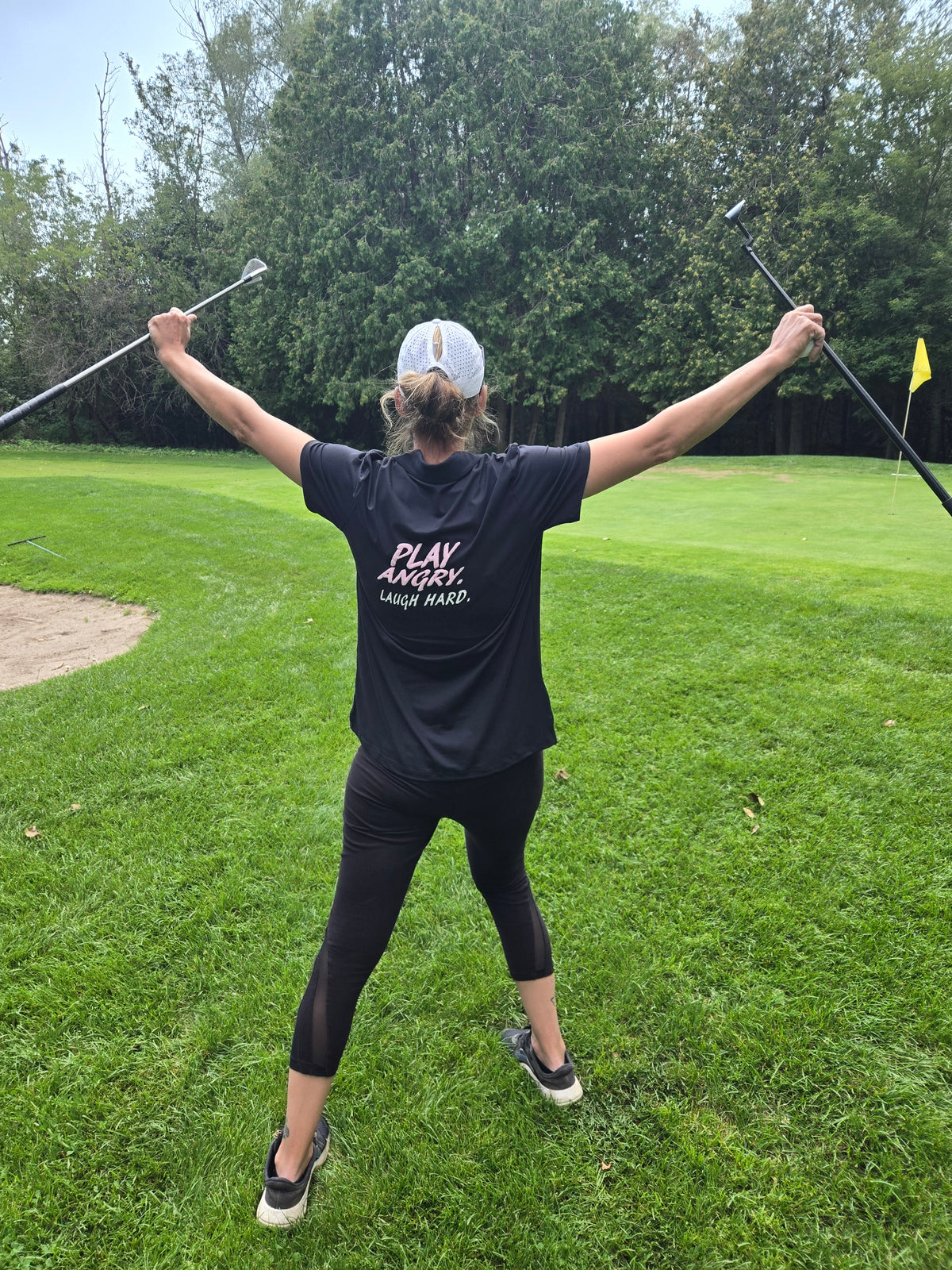Golfer wearing a black GGGGRRRRR GOLF shirt on the course